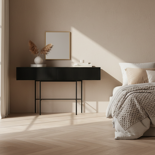 A modern black console table with a ribbed front, three drawers, and slim metal legs, shown against a solid off-white background.